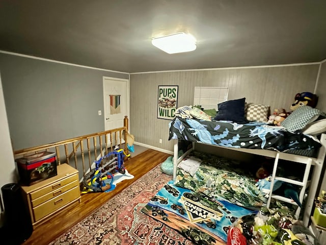 bedroom with crown molding, baseboards, and wood finished floors