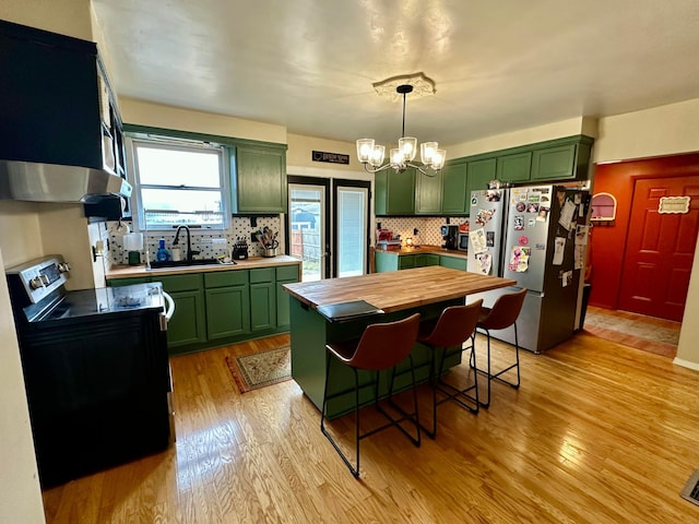 kitchen featuring freestanding refrigerator, green cabinetry, a sink, and black range with electric cooktop