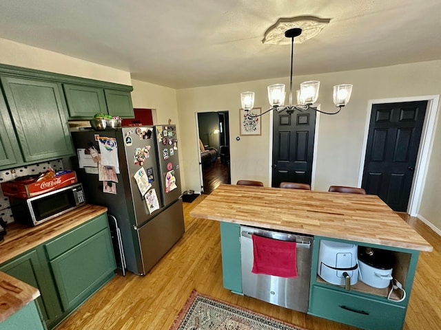 kitchen with a notable chandelier, butcher block counters, appliances with stainless steel finishes, and green cabinetry