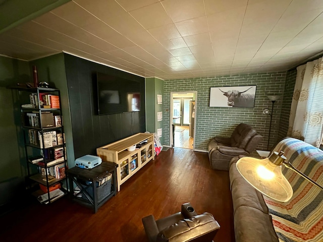 living room featuring brick wall and wood finished floors