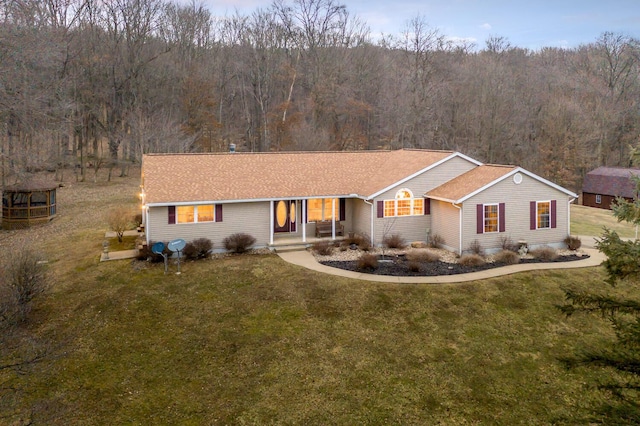 single story home featuring a front lawn and a view of trees