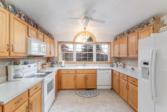 kitchen featuring light countertops, backsplash, vaulted ceiling, a sink, and white appliances