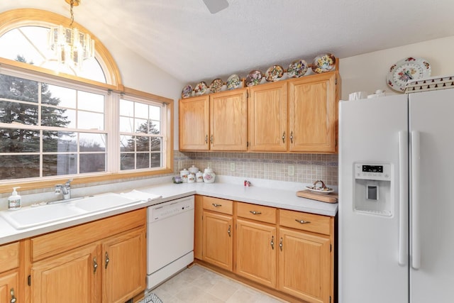 kitchen with lofted ceiling, white appliances, light countertops, and a sink