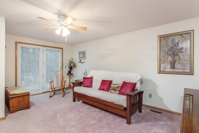 living room featuring a ceiling fan, carpet, visible vents, and baseboards