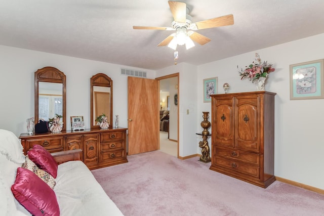 living area with a ceiling fan, light colored carpet, visible vents, and baseboards