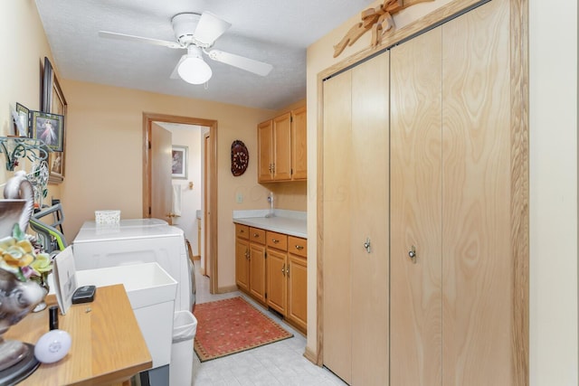 clothes washing area with a textured ceiling, separate washer and dryer, a ceiling fan, cabinet space, and light floors