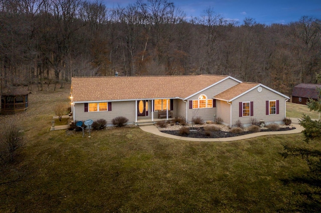 single story home with a front yard and a view of trees