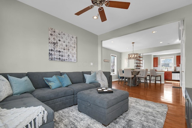 living room featuring baseboards, wood finished floors, a ceiling fan, and recessed lighting