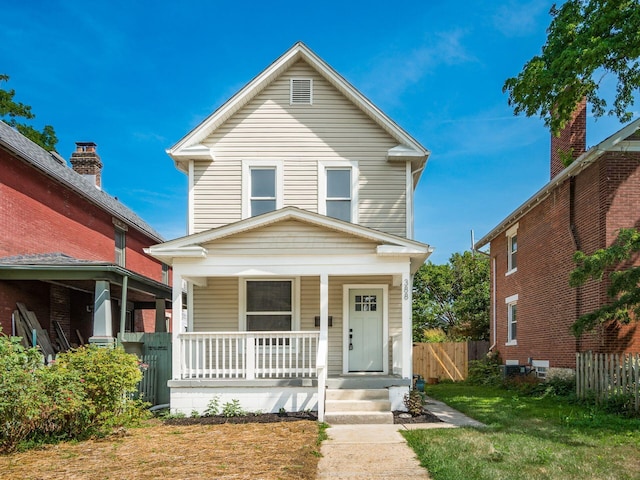 view of front of home featuring covered porch and fence