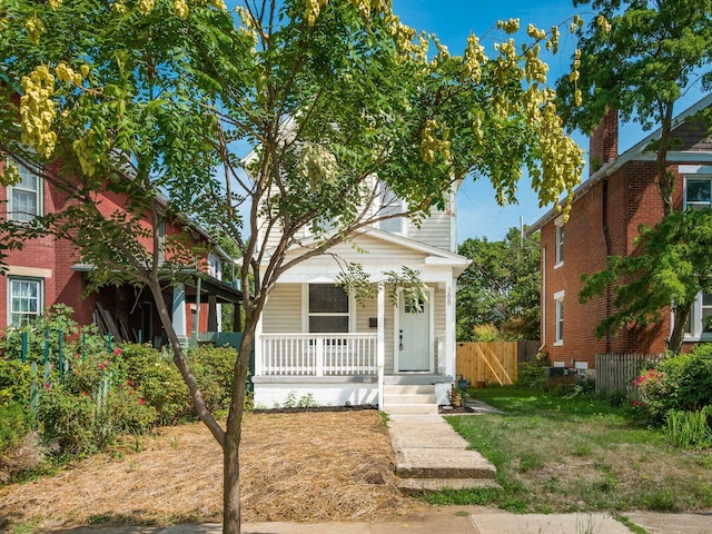 view of front of home featuring covered porch and fence