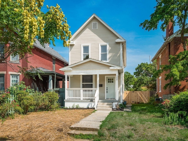 view of front of home with a front lawn, fence, and a porch