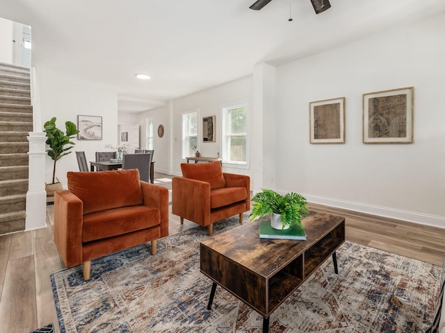 living area featuring recessed lighting, a ceiling fan, wood finished floors, baseboards, and stairs