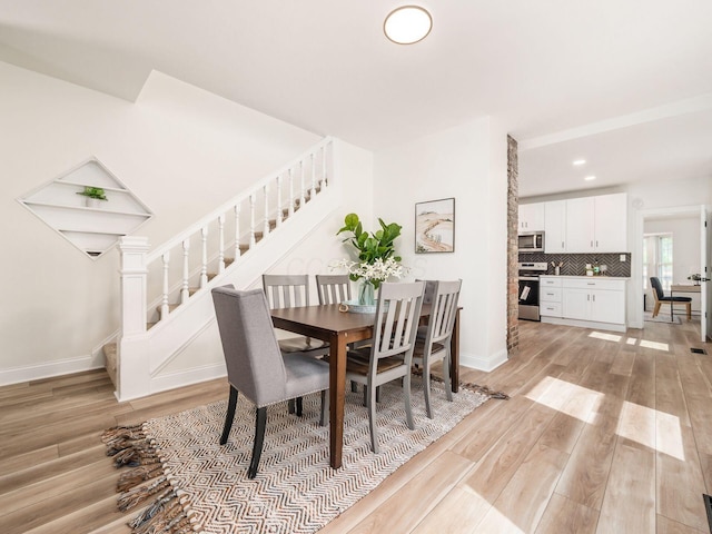 dining space featuring stairs, light wood finished floors, recessed lighting, and baseboards