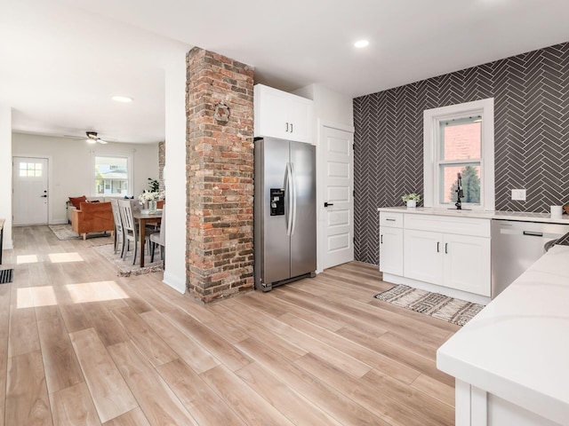 kitchen with white cabinets, stainless steel appliances, light wood-style floors, a sink, and recessed lighting