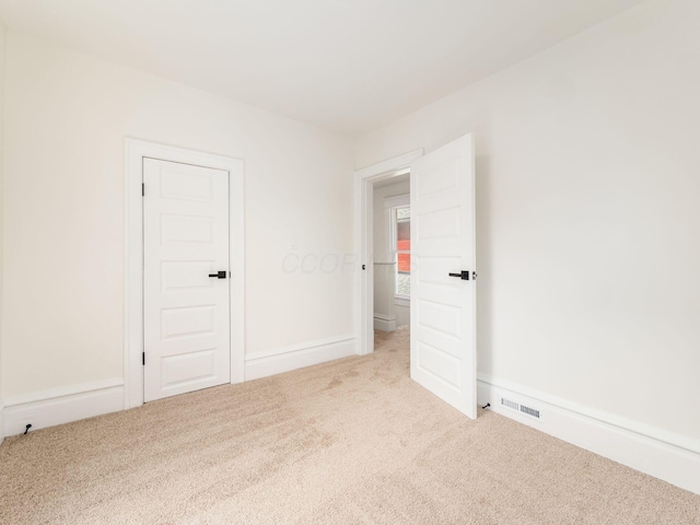 carpeted spare room with baseboards and visible vents