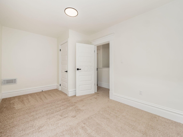 unfurnished bedroom with carpet, visible vents, and baseboards