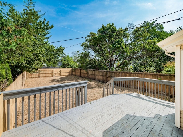 wooden terrace with a fenced backyard