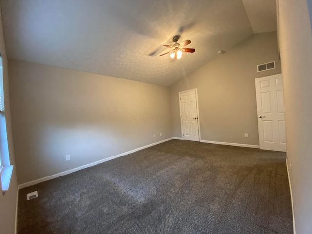 spare room featuring lofted ceiling, baseboards, visible vents, and a ceiling fan