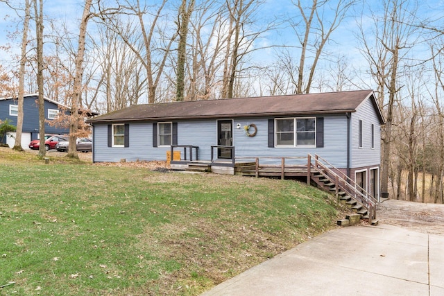 single story home with a wooden deck, driveway, and a front yard