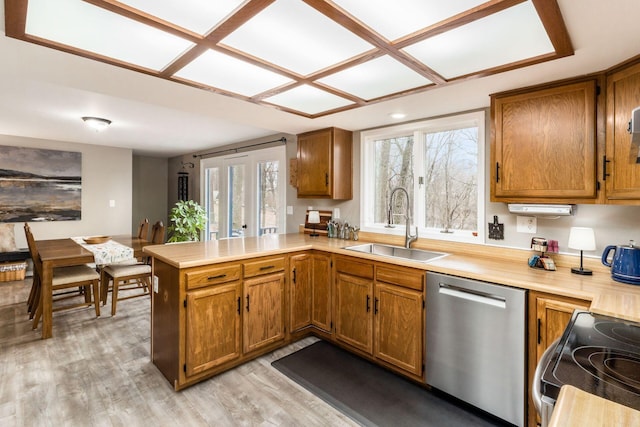 kitchen featuring light countertops, a peninsula, stainless steel dishwasher, electric range, and a sink