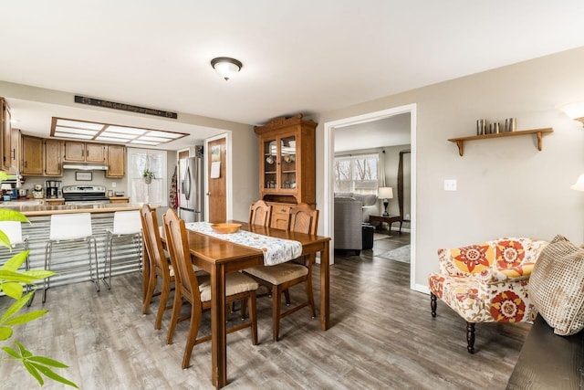 dining space with light wood-type flooring and baseboards