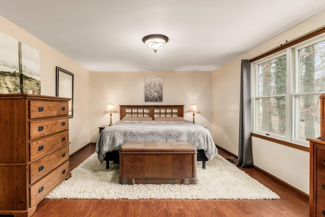 bedroom featuring baseboards and wood finished floors