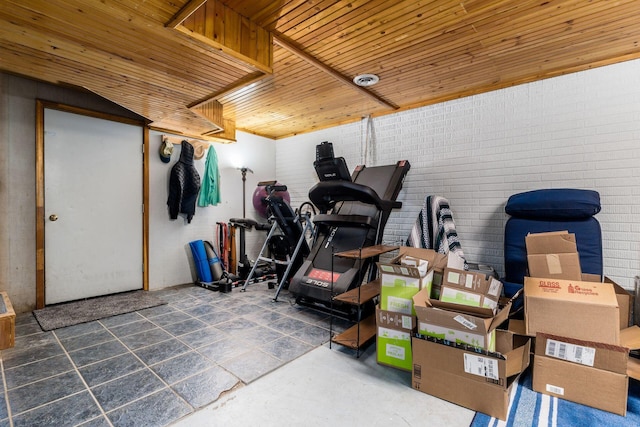 interior space featuring wooden ceiling and brick wall