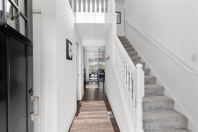 entrance foyer with stairs, a high ceiling, and wood finished floors