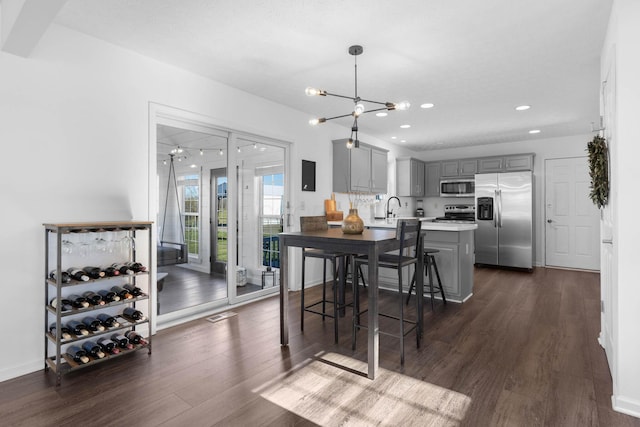 dining room featuring recessed lighting, dark wood-style flooring, and baseboards