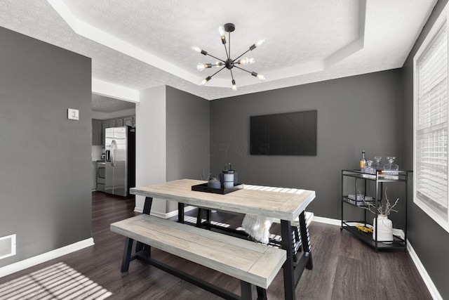 dining room with a tray ceiling and baseboards