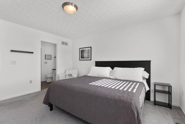 carpeted bedroom featuring visible vents, connected bathroom, a textured ceiling, and baseboards