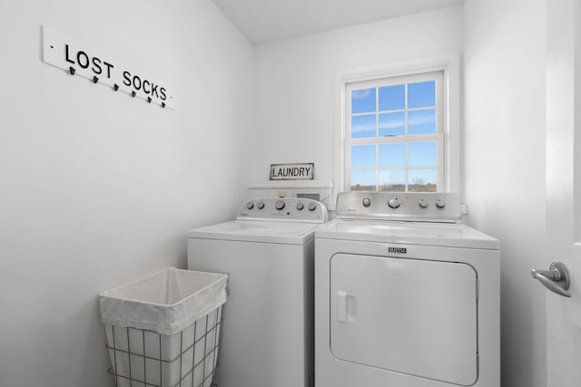 clothes washing area featuring washing machine and dryer, laundry area, and a sink