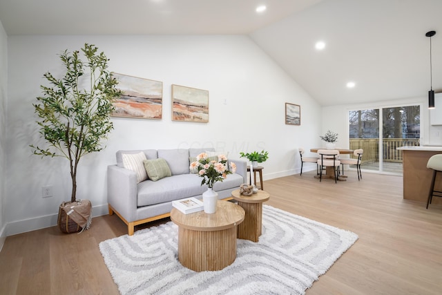 living area with light wood-type flooring, recessed lighting, baseboards, and lofted ceiling