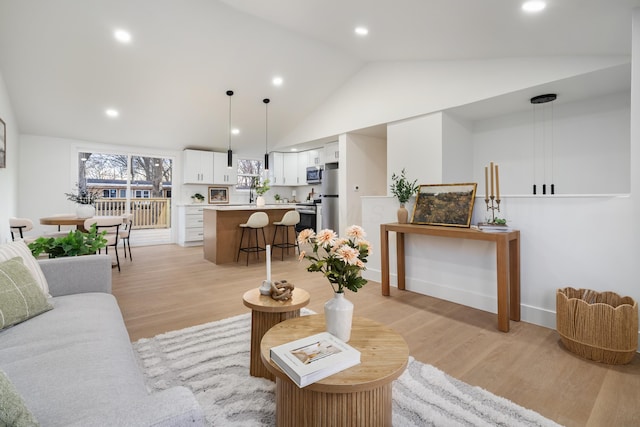 living area with vaulted ceiling, recessed lighting, baseboards, and light wood-style floors