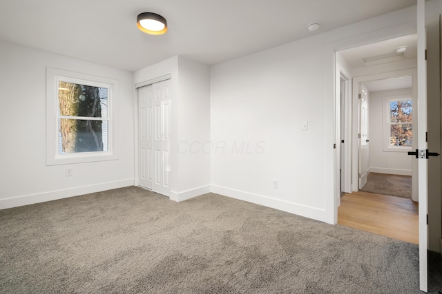 carpeted empty room featuring baseboards