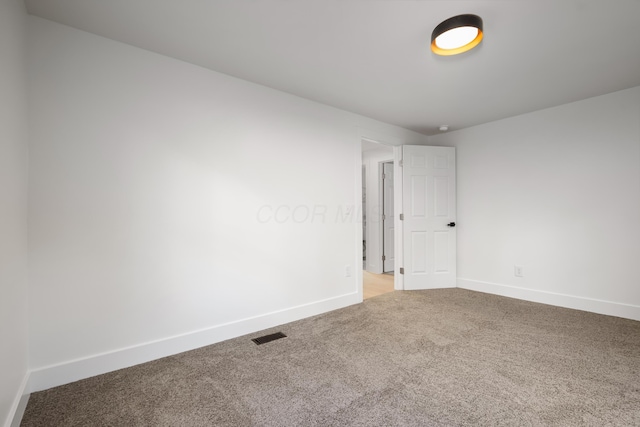 carpeted empty room featuring baseboards