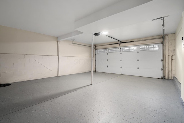 garage with concrete block wall and a garage door opener