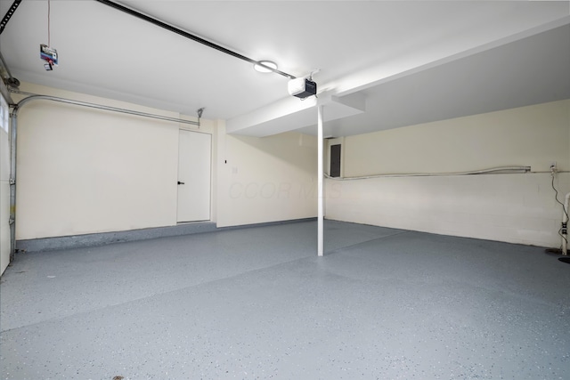 garage featuring concrete block wall and a garage door opener