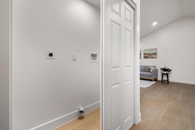 laundry room featuring laundry area, light wood-style flooring, baseboards, and hookup for an electric dryer