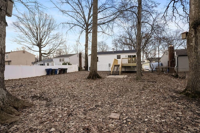 rear view of property with a fenced backyard and a deck