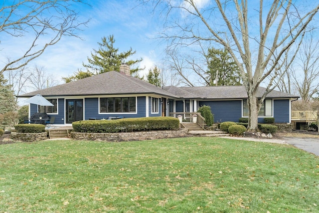 ranch-style home featuring a chimney and a front lawn