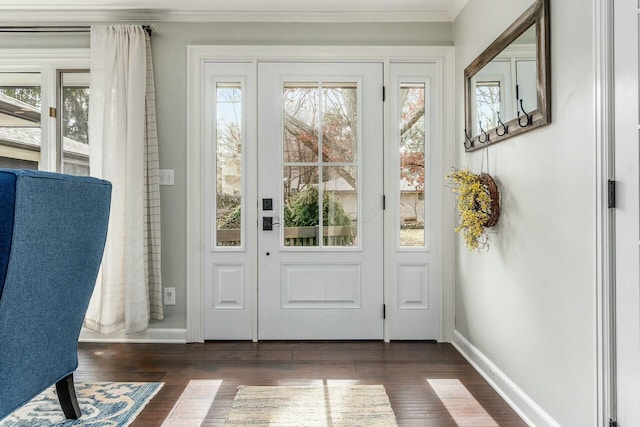 doorway with ornamental molding, baseboards, and dark wood-style flooring