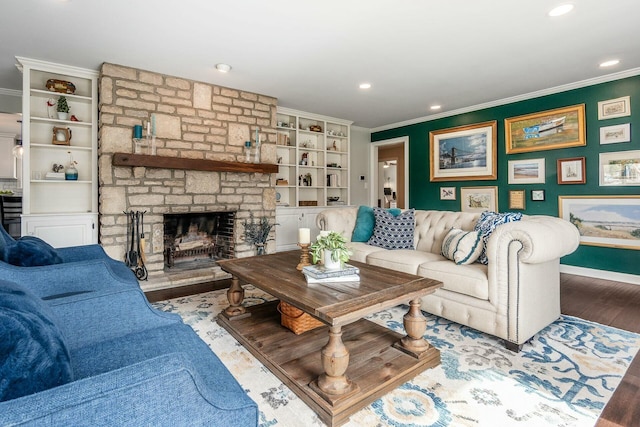 living area with crown molding, baseboards, a stone fireplace, recessed lighting, and wood finished floors