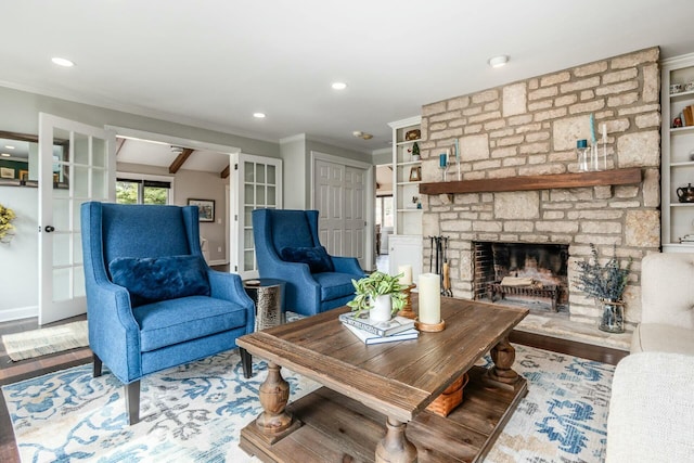 living area featuring a stone fireplace, recessed lighting, wood finished floors, and ornamental molding