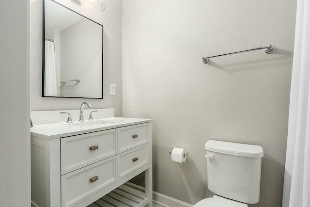 bathroom featuring baseboards, toilet, and vanity