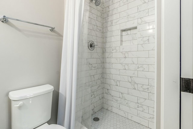 bathroom featuring toilet and a shower stall