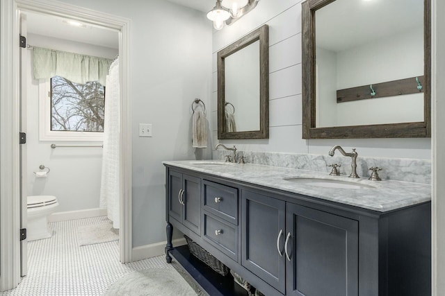 full bath with tile patterned floors, toilet, double vanity, and a sink