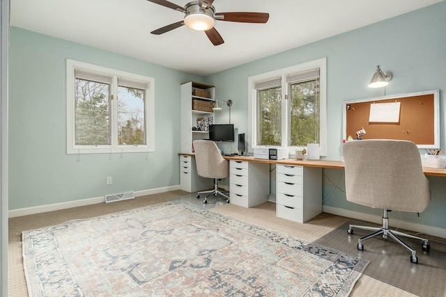 home office with a wealth of natural light, visible vents, and baseboards