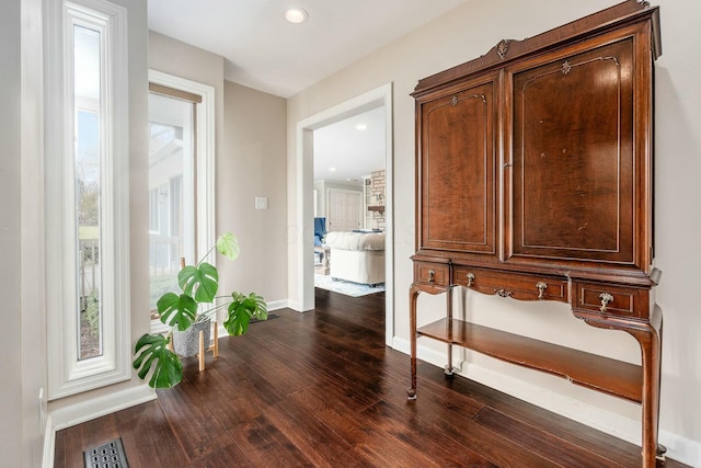 hall with recessed lighting, visible vents, baseboards, and dark wood-style flooring