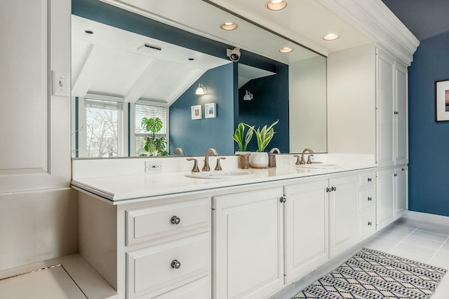 full bathroom featuring double vanity, vaulted ceiling, tile patterned floors, and a sink